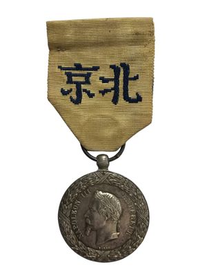 une vieille médaille en argent sur laquelle figure une inscription en chinois