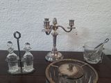 a glass bowl on a table with a candle holder and other items