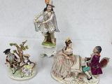 four figurines of people sitting on a bench