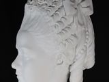 white marble bust of a woman wearing a headdress and a turban