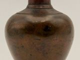 a brown vase that is sitting on a white surface