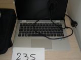 un ordinateur portable posé sur un bureau sur lequel figure un numéro