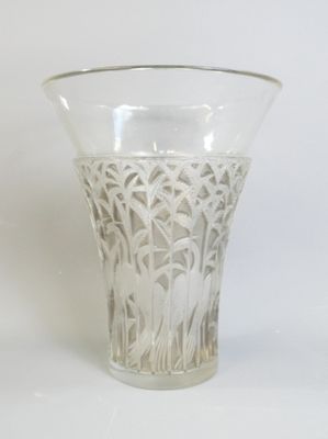 un vase en verre orné d'un motif sur un fond blanc