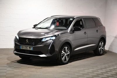 La voiture grise est garée dans le garage de l'immeuble.