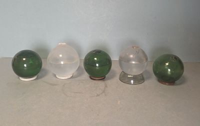 quatre boules de verre posées les unes à côté des autres sur une table