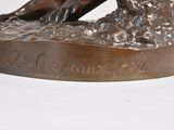 bronze statue of a dog with a ball in its mouth on a base