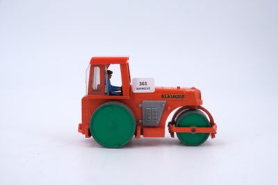a red toy tractor with a green wheel on a white surface