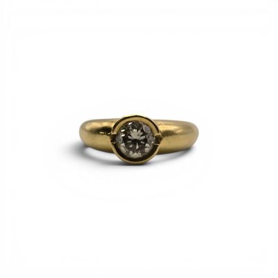 a close up of a gold ring with a white diamond