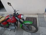 a red and green motorcycle parked on the side of the street