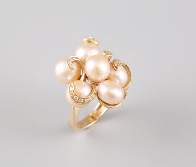 une bague en or ornée de perles et de diamants sur fond blanc