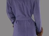 a woman wearing a purple coat with a fur collar