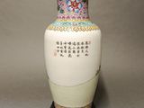 a white vase with oriental writing on it sitting on a table