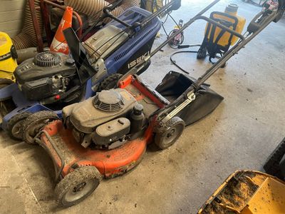 an image of a lawn mower and other tools in a garage
