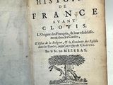 un vieux livre sur lequel est collé un autocollant, posé sur une table