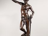 une statue en bronze représentant un homme tenant une épée et debout sur un rocher