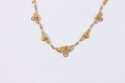 gros plan d'un collier en or sur fond blanc