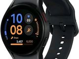 une image représentant une montre connectée noire rehaussée de touches orange sur fond blanc