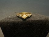 a close up of a gold ring with a heart shaped diamond