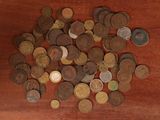 a pile of old coins on a wooden table