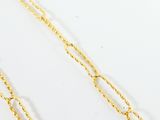 a close up of two gold chains on a white surface