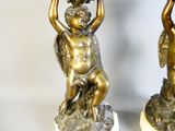 deux statues représentant un garçon et une fille, posées sur un socle