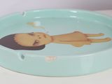 a blue ashtray with a picture of a woman on it