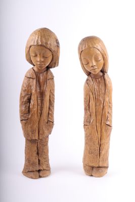 une paire de figurines en bois sculpté représentant un garçon et une fille debout l'un à côté de l'autre