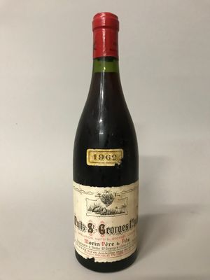 une vieille bouteille de vin posée sur une table blanche