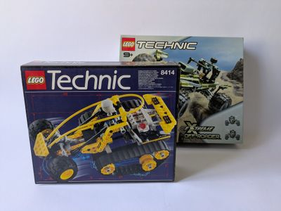 deux véhicules lego technic sont assis l'un à côté de l'autre sur une surface blanche