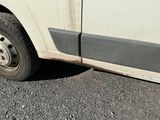 une photo d'une camionnette sale garée sur le bord de la route