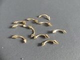 six petits dauphins dorés sont posés sur une surface noire