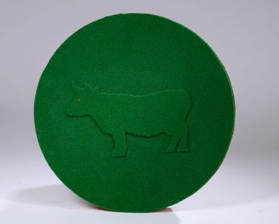 a green plate with a picture of a cow on it