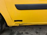 a yellow car that is parked in a parking lot