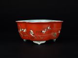 un bol rouge orné d'oiseaux et de fleurs sur un fond noir