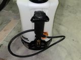 a white container with a black cap and a hose attached to it