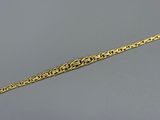 a close up of a gold chain bracelet on a gray surface