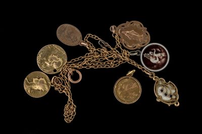 plusieurs types différents de pièces d'or et de breloques suspendues à une chaîne