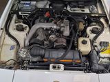 a white car with its hood open and the engine in it