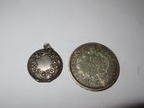 two silver coins sitting next to each other on a white surface