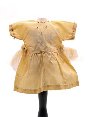 une robe jaune sur une tête de mannequin, sur fond blanc