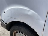 a close up of a white truck with a flat tire