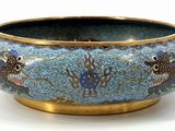 a blue bowl with fish on it on a white surface