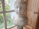 a stone bust sitting on top of a wooden table