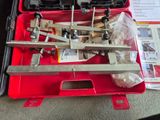 une mallette rouge contenant des outils, posée par terre
