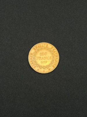 gros plan d'une pièce d'or sur une surface noire