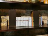 a book shelf with books and vases on it