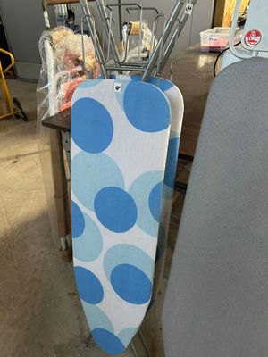 une planche à repasser à pois bleus et blancs et une planche à repasser bleue et blanche posée sur une table