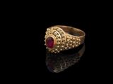 une image représentant une bague en or ornée d'un rubis au centre