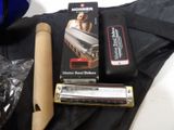 a harmonica, a harmonica case, and a pair of scissors on a table