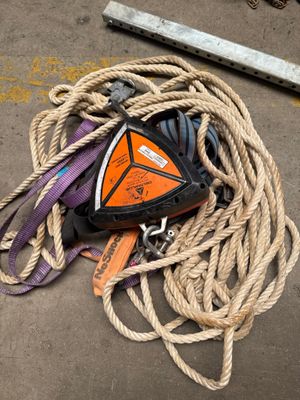 a pile of rope on the ground next to a piece of equipment